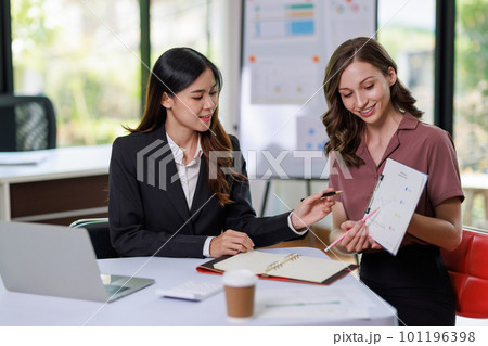 Concept of business office woman working,Businesswoman smile while working about her invesment plan with analyzing document and business investment graph data by using laptop on desk in workstation. Concept of business office woman working,Businesswoman smile while working about her invesment plan with analyzing document and business investment graph data by using laptop on desk in workstation. 101196398