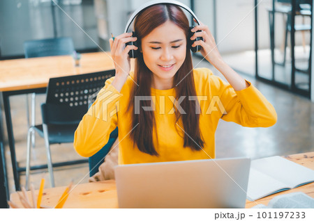 young student wearing headphones studies online, distance learning, and keeps up to date on the global coronavirus pandemic. 101197233