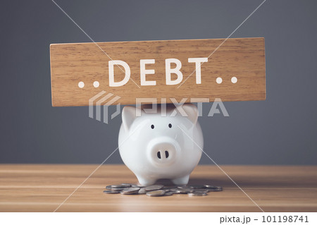 Financial problem, Bankrupt or fail in business concept. White of new piggy bank, coin stack and word DEBT write on wooden board on wooden desk with dark wall. Financial problem, Bankrupt or fail in business concept. White of new piggy bank, coin stack and word DEBT write on wooden board on wooden desk with dark wall. 101198741