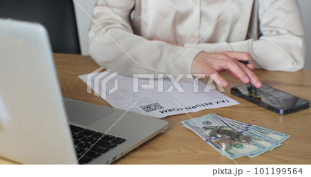 Close up woman filling tax return form. Female calculating expenses and writing on tax document. 101199564