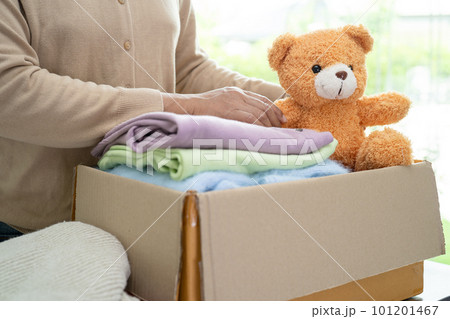 Donation box with used clothes and doll at home to support help for poor people in the world. 101201467