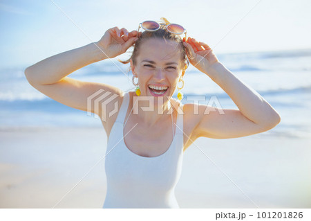 smiling elegant woman in swimwear at beach having fun time smiling elegant woman in swimwear at beach having fun time 101201826