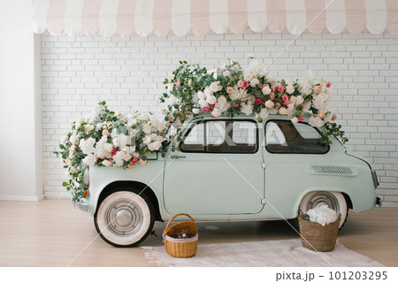 Retro mint car decorated with flowers in the photo zone in a romantic style for Spring Day or St. Valentine 101203295