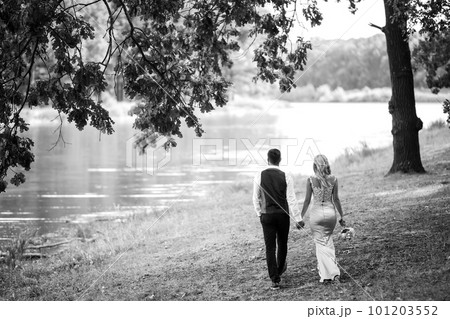 Stylish couple of happy newlyweds posing in the park on their wedding day. Perfect couple bride. 101203552