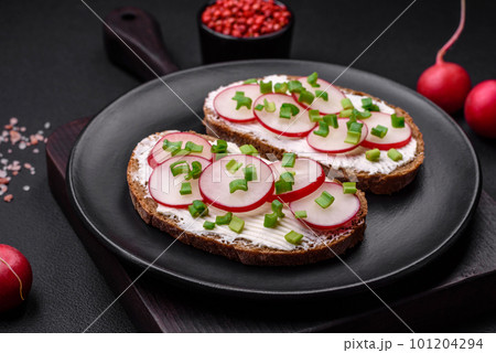 Delicious sandwich or bruschetta with cream cheese radish and green onions 101204294