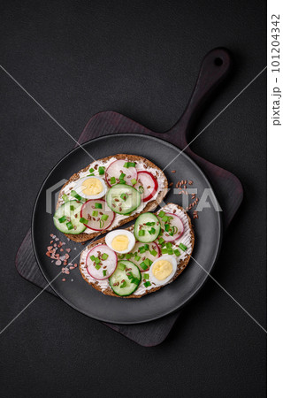 Delicious sandwich or bruschetta with cream cheese radish and green onions 101204342