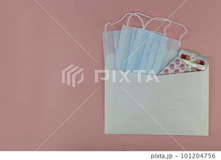 medical masks and tablets in an envelope on a pink background, isolates, mockup medical masks and tablets in an envelope on a pink background, isolates, mockup 101204756