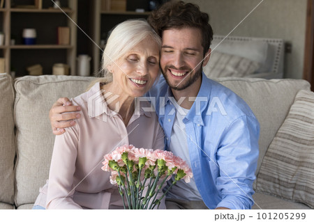 Cheerful young adult guy congratulating mom on 8 march 101205299
