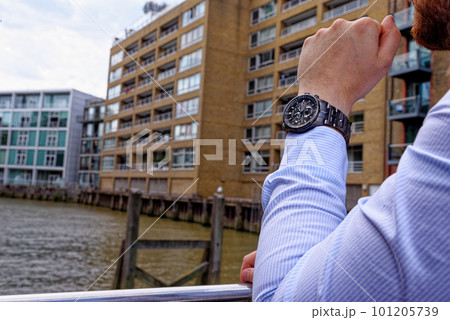 Young man in China Wharf London wearing fashion watch 101205739
