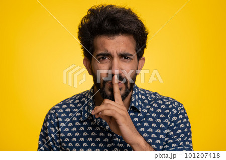 Young indian man presses finger to lips makes silence gesture sign do not tells secret, stop gossip Young indian man presses finger to lips makes silence gesture sign do not tells secret, stop gossip 101207418