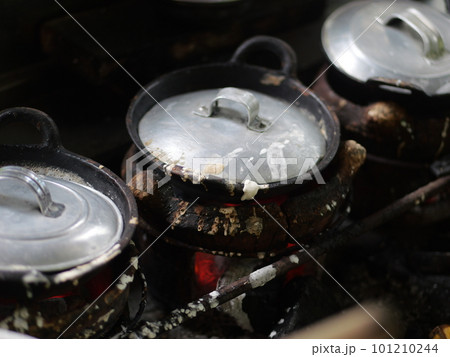The making of a traditional Indonesian cake, originating from the Java region, named "surabi" is made from rice flour and placed in a small frying pan and topped with various toppings such as cheese.  101210244