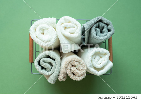 Bathroom shower towels in basket on green background. top view 101211643