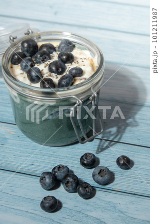 Glass jar with natural organic homemade yogurt and blueberries spirulina chlorella superfood super powder blue algae sea weed. Immunity-boosting ingredients. Concept of healthy eating breakfast of Glass jar with natural organic homemade yogurt and blueberries spirulina chlorella superfood super powder blue algae sea weed. Immunity-boosting ingredients. Concept of healthy eating breakfast of 101211987