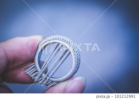 Man is holding object printed on metal 3d printer. Object printed in laser sintering machine. Modern 3D printer printing from metal powder. Progressive additive DMLS, SLM, SLS 3d printing technology 101212991