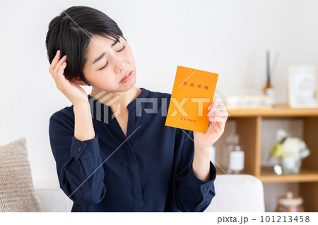 年金手帳を持って悩む女性 年金手帳を持って悩む女性 101213458