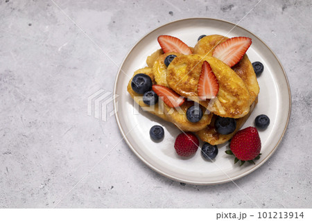Flatly French Toast, Spanish Torrijas Made Of Sliced Baguette, Bread, Served With Orange Topping, Glaze, Fresh Blueberries, Strawberry On Granite Table. Copy Space For Text. Horizontal plane. 101213914