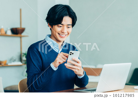 テレワークでスマホを使う若い男性 テレワークでスマホを使う若い男性 101217985