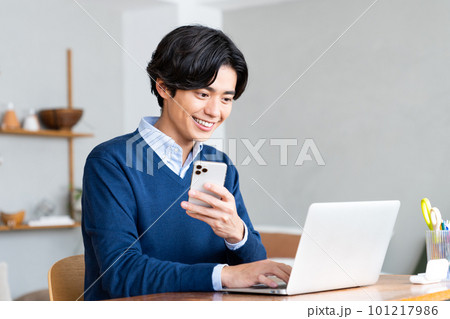 テレワークでスマホを使う若い男性 テレワークでスマホを使う若い男性 101217986