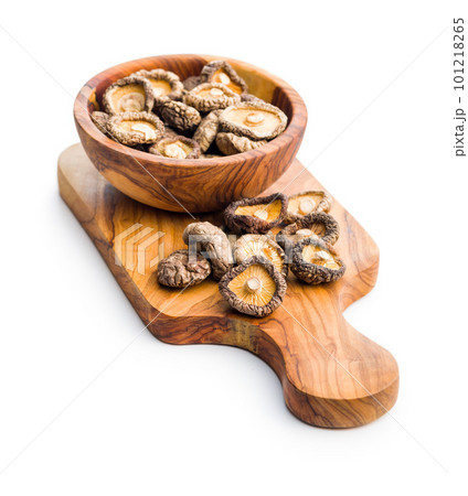 Dried shiitake mushrooms on cutting board isolated on white background. 101218265