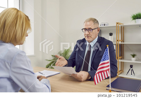 Worker at Consulate of United States of America gives woman travel visa application Worker at Consulate of United States of America gives woman travel visa application 101219545