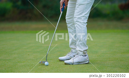 Golfer putting ball on the green golf, lens flare on sun set evening time. Golfer putting ball on the green golf, lens flare on sun set evening time. 101220102