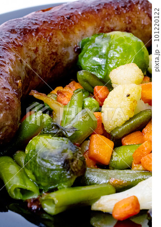 Grilled vegetables and sausage on a black plate Grilled vegetables and sausage on a black plate 101220122