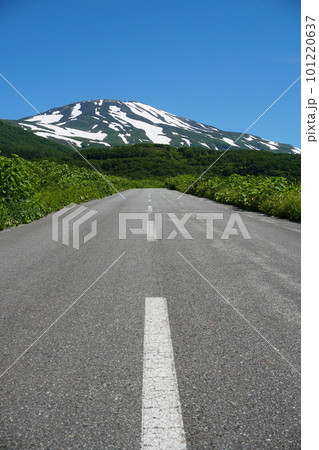 青空を背景にした残雪の鳥海山と鳥海高原ラインの道　Ver1 101220637