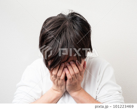 両手で顔を覆う男性 101223469