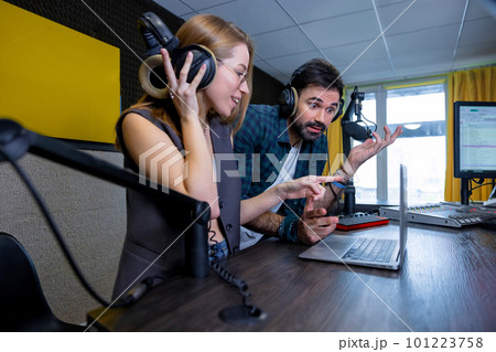 Two team members having a sound check and looking involved Two team members having a sound check and looking involved 101223758