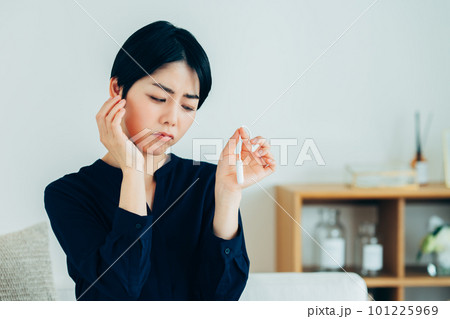 タンポンを見て悩む若い女性 101225969