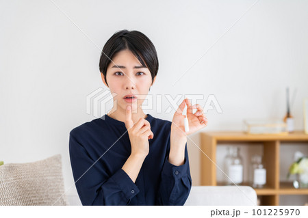 タンポンを見て悩む若い女性 101225970