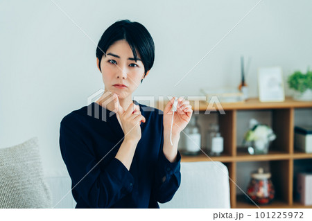 タンポンを見て悩む若い女性 101225972