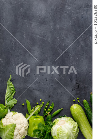 Border of organic green raw vegetables on black table. Top view of healthy organic food. Copy space 101226380