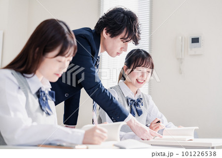 教室で先生に質問をする高校生 101226538