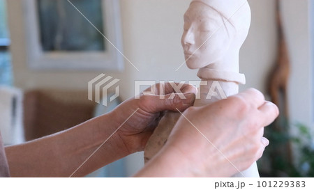 a sculpture girl polishes a limestone statue with sandpaper in a 101229383