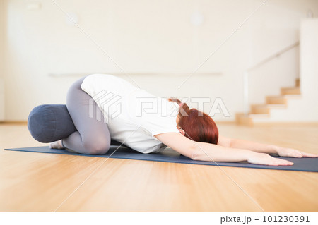 pregnant woman is engaged in yoga. Children asana with knees apart or Balasana pregnant woman is engaged in yoga. Children asana with knees apart or Balasana 101230391