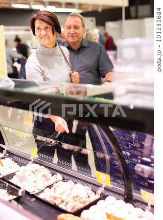Mature couple choosing piece of meat in meat department in grocery store 101231684