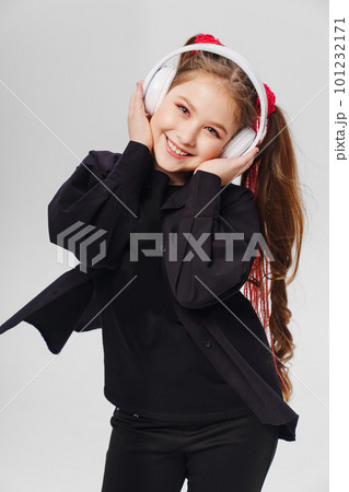 a teenage girl with ponytails in black clothes on a white background 101232171
