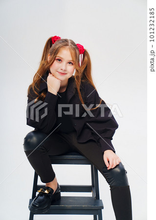 portrait of a teenage girl with ponytails in black clothes on a white background 101232185
