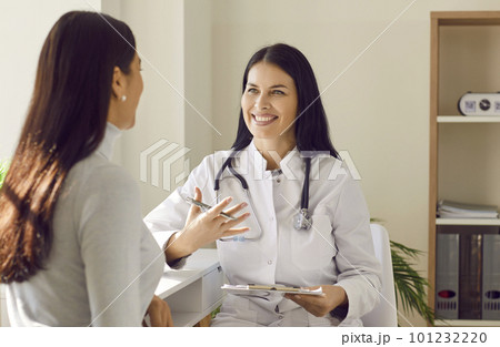 Doctor holding report file with appointment and giving consultation to a woman patient. 101232220