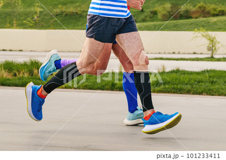 legs two male runners in compression socks and sleeves run legs two male runners in compression socks and sleeves run 101233411