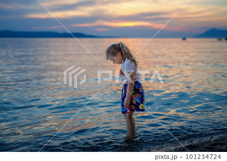 Little girl walking on beautiful ocean beach. Happy preschool child play by sunset on sea beach. Family vacations with children in summer. Little girl walking on beautiful ocean beach. Happy preschool child play by sunset on sea beach. Family vacations with children in summer. 101234724