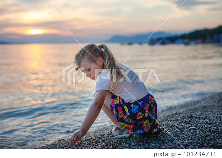 Little girl walking on beautiful ocean beach. Happy preschool child play by sunset on sea beach. Family vacations with children in summer. Little girl walking on beautiful ocean beach. Happy preschool child play by sunset on sea beach. Family vacations with children in summer. 101234731