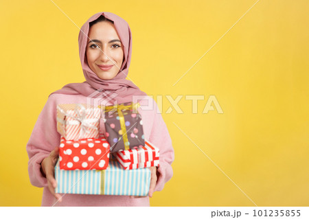 Muslim woman smiling with many gifts in the hands Muslim woman smiling with many gifts in the hands 101235855