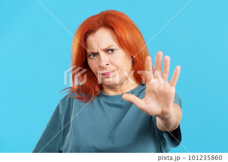 Redheaded mature woman gesturing prohibition with hand 101235860