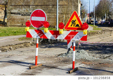 Red and white striped warning barrier with lights and prohibition signs before street repair site Red and white striped warning barrier with lights and prohibition signs before street repair site 101236858