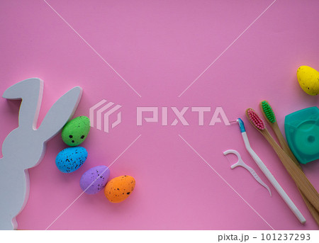 Wooden toothbrushes with Easter decorations on pink background 101237293