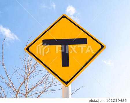 道路標識(警戒標識)「T形道路交差点あり」と青空。 101239486