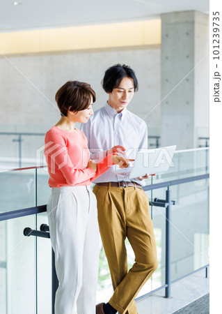 オフィスでパソコンを見ながら打ち合わせする男女 101239735