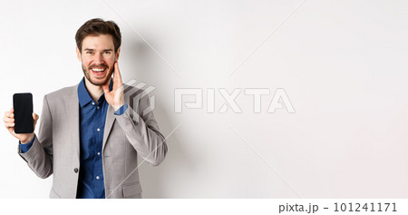 E-commerce and online shopping concept. Happy bearded guy in suit showing empty smartphone screen and laughing, standing on white background 101241171